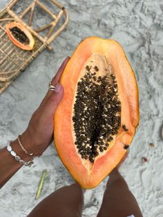 a person holding a half eaten papaya in their hand