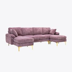 a purple sectional sofa with gold legs and footrests on an isolated white background