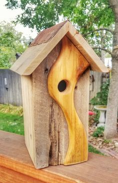 a bird house made out of wood on top of a wooden table