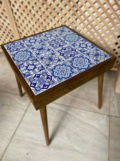 a blue and white table sitting on top of a tiled floor