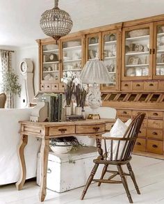 a room filled with lots of wooden furniture and white flooring next to a window