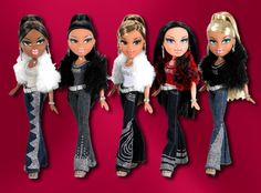 five dolls are lined up on a red background, one is wearing black and the other has blonde hair