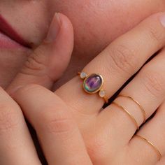 a close up of a person's hand with a ring on it and an amethyst stone