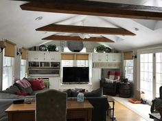 a living room filled with furniture and a flat screen tv mounted to the wall above it