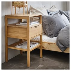 a bed with a wooden night stand next to it