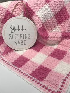 a pink and white checkered blanket with a tag that says, sleep sleeping babe