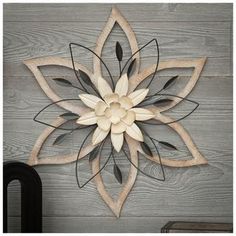 a wooden wall hanging with a metal flower on it