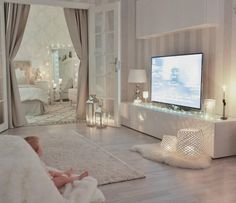 a baby laying on the floor in front of a flat screen tv with candles around it