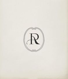 the letter r is inscribed in black on a white paper with an ornate border around it