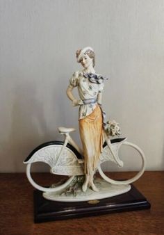 a figurine of a woman on a bicycle