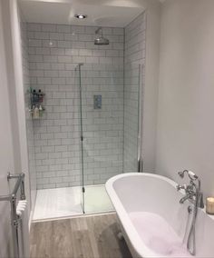 a white bath tub sitting next to a walk in shower