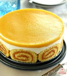 a yellow cake sitting on top of a black plate