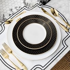 a black and white place setting with gold accents