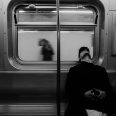 a person sitting on a train looking out the window at something in front of them