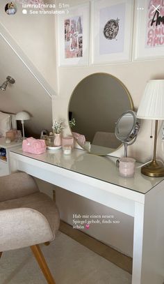 a white desk topped with a mirror next to a chair and table lamp in a room