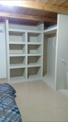 an empty bedroom with white shelving in it