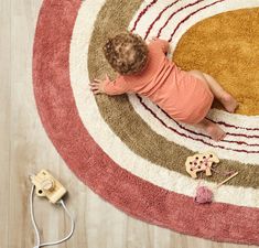 a small child laying on top of a rug