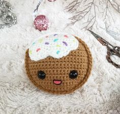 a crocheted donut with sprinkles on it sitting next to scissors