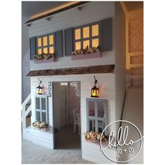 a white doll house with windows and lights