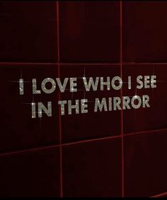 the words i love who i see in the mirror are written on a wall next to a urinal