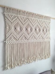 a white wall hanging with tassels on it