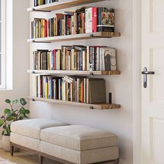 a living room filled with lots of books on shelves next to a door and window