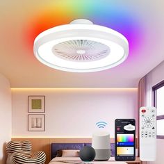 a room with a bed, remote control and colorful lights on the ceiling above it