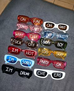 six pairs of sunglasses with words on them sitting on the floor next to each other