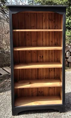 a wooden bookcase with three shelves in it