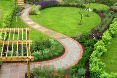 an aerial view of a garden with a wooden gazebo in the center and landscaping around it