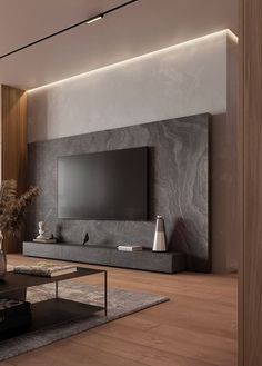 a living room with a large tv mounted on the wall next to a coffee table