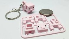 a keychain that is shaped like a house and has two pigs on it