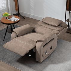 a recliner chair sitting on top of a rug in a living room next to a table