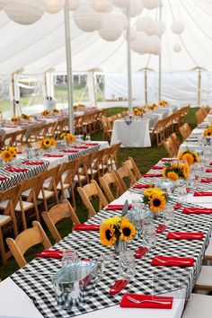 a table with sunflowers is set up in a tent for an outdoor party