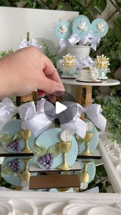 a person is holding some decorative items in front of a table with flowers and other decorations