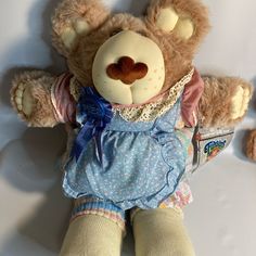 a brown teddy bear wearing a blue dress