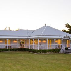 a large white house sitting on top of a lush green field