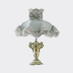 an ornate lamp with a bow on it's head and lace trimmings