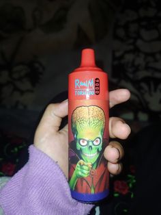 a person holding up a bottle with an image of a zombie on it's side