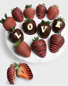 chocolate covered strawberries arranged on a plate with the word love spelled out in letters