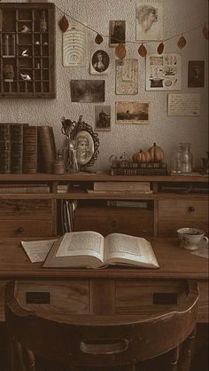 an open book sitting on top of a wooden table next to a shelf filled with books