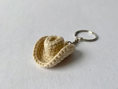 a crocheted keychain with a small hat on it's side