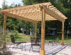 a wooden pergola sitting on top of a stone patio