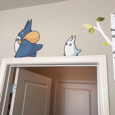 two birds are sitting on top of a mirror in a room with gray walls and white trim