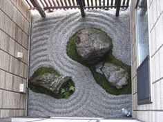 two rocks in the middle of a rock garden with moss growing between them and an open door