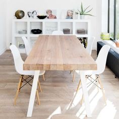 a dining room table with white chairs around it