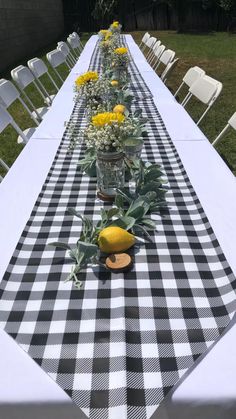 a long table covered in black and white checkered cloth with lemons on it