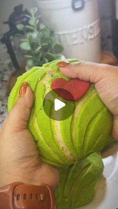 a person is peeling an artichoke with their thumb and holding it up to the camera