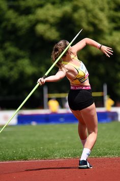 a woman holding a pole on top of a field