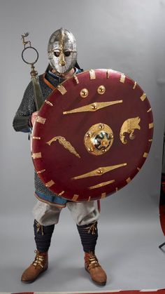 a man dressed in armor and holding a shield